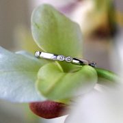 Ring with solid white gold parts and diamonds in closed setting, arranged in an irregular manner. This ring can be combined with an engagement ring or worn alone.