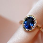 The yellow gold engagement ring, with sapphire and its diamond surround, is a vintage engagement ring in its style, with a modern side by the square shape of its body.