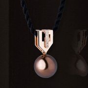 necklace-gold-felicia The "Félicia" contemporary art deco style pendant is made of red gold and set with diamonds. A chocolate cultured pearl is suspended from it. This jewel is signed by Annette Girardon.