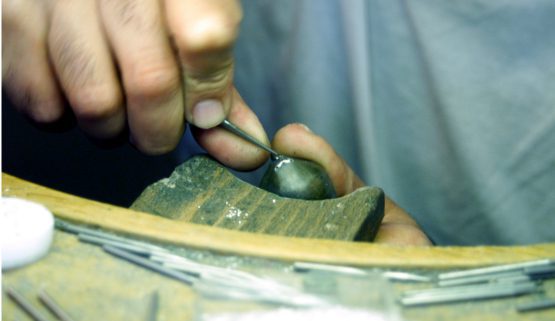 setting-jewelry-craftsmen A craftsman, specialized in stone setting, Here, a stone is being set in a handcrafted jewel according to french jewelry tradition.
