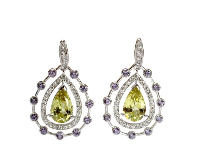Fine jewellery earrings in pear shape and white gold with chrysoberyl in the center and diamonds and purple sapphires arround them.