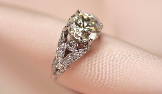 Romantischer Verlobungsring in Weissgold mit Diamanten Romantischer Verlobungsring in Weissgold, mit Diamanten besetzten Blättchen neben dem Zentralstein.kleinen