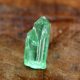 Lagoon green rough tourmaline on a wooden background.