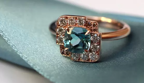 Custom made rose gold engagement ring with an aquamarine cushion, set in a square, paved with white and brown diamonds. This design is inspired by the Art Deco style.