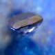 Tanzanite gemstone seen in profile in front of lapislazuli, as introduction for an article about the meaning of stones.