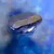 Une tanzanite en vue de profil contre du lapis lazuli, flou au fond, comme introduction d'un article traitant de la signification des pierres.
