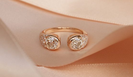 Bague de fiançailles sur-mesure, serties de diamants anciens Cette bague de fiançailles originale, qu'on nomme toi et moi est façonnée en or rouge est ouverte au centre. Deux diamants de taille ancienne sont placés des deux côtés de l'ouverture. Un pavage de diamant s'étale sur l'anneau qui s'affine fur et à mesure.