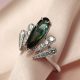 Cette bague de fiançailles originale évoque la plume d'un paon, avec sa toumaline bleue verte en forme de poire allongée au centre et accomagnée par des motifs pavés de diamants. C'est une création sur-mesure par la joaillière parisienne Annette Girardon.