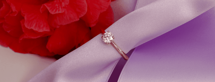 Vous cherchez un conseil pour choisir une bague de fiançailles? Cette photo montre un solitaire en or rouge, serti d'un diamant en introduction d'un article de blog.