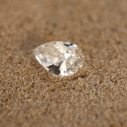Diamants pour bague homme Un diamant poire est posé dans du sable. Annette Girardon crée des bagues pour homme avec des pierres précieuses.