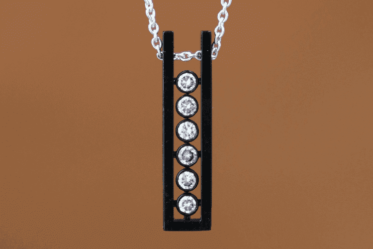 createur-bijoux-homme-paris Six diamants sont sertis en ligne dans un pendentif en forme U, en or noir personnalisé. La créatrice Annette Girardon propose des créations de bijoux homme sur-mesure, à Paris.