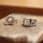 Deux bagues sont posée sur un établi de joaillier. Le diamant de centre a été prélevé sur l'une d'entre elles pour être monté dans une bague sur-mesure à Paris.