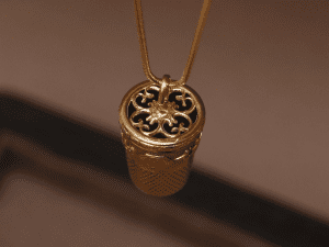 transformation-bijoux Un élément filigrane, inventé par la joaillière Annette Girardon transforme ce dès de couture en or en un pendentif.