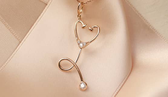 Un pendentif en or rouge et diamants, en forme de stéthoscope, créé sur mesure par Annette Girardon à Paris.