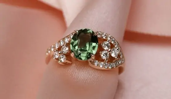 bague-saphir-fiancaille Un saphir vert non chauffé se trouve au centre d'une bague de fiançailles asymétrique en or jaune, pavé de diamants, créée par la joaillière parisienne, Annette Girardon.
