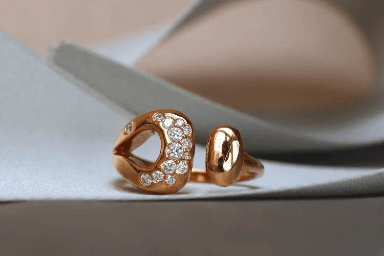 Bague en or rouge avec des diamants de pavage, style toi et moi, ouverte au milieu. C'est un design de la joaillière Annette Girardon à Paris.