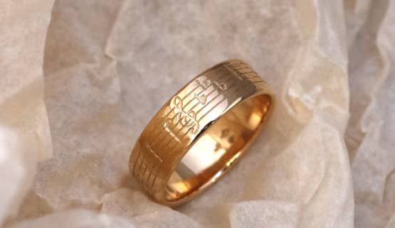 Ein Ring aus Gelbgold mit eingravierten Noten vom Beginn der historischen Symphonie. Maßgeschneidert in Paris.
