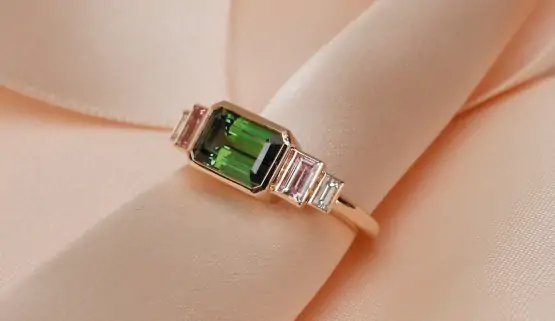 fiancaille-sur-mesure-paris Cette bague de fiançailles sur-mesure est sertie d'une tourmaline verte hexagonale, épaulée par deux baguettes de saphirs roses, puis de diamants.