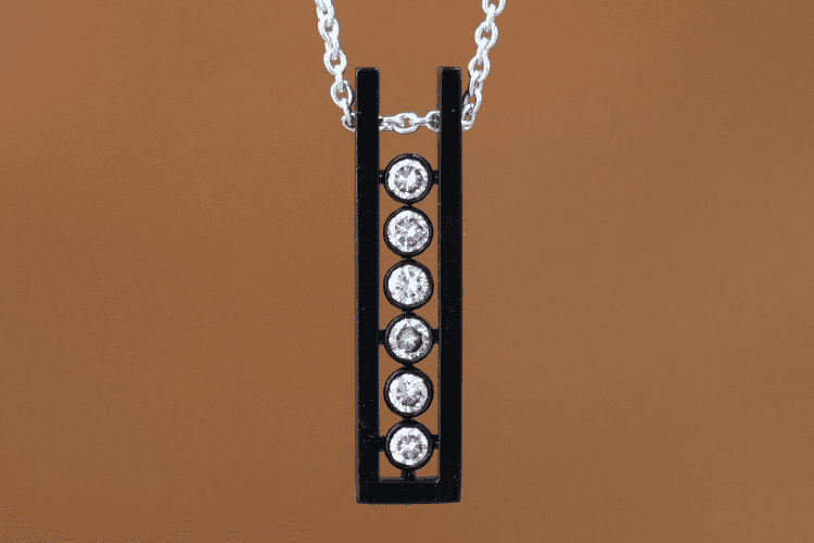 black-gold-diamond-pendant Six diamonds are set in a row in a U-shaped pendant made of custom black gold. Designer Annette Girardon offers bespoke jewelry creations for men in Paris.
