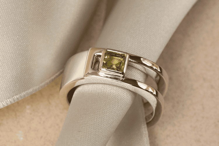 engagement-ring-for-men Parisian luxury is represented here in the form of a platinum men's ring. Its partially open band is set with a peridot. Annette Girardon is also a brand for high-quality men's jewelry.