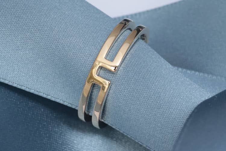 herrenringe-in-gold Dieser Ehering für Herren aus Rotgold besteht aus zwei quadratischen Ringen, die in der Mitte durch eine U-Form miteinander verbunden sind. Dieser Ring wurde in Paris, im Viertel rund um die Place Vendôme, maßgefertigt.