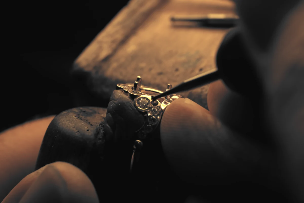 Fabrication d'une bague de fiançailles sur mesure dans un atelier parisien de sertissage.
